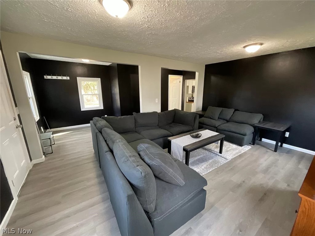 1850 Ronald Road Akron, OH 44312 - Photo 11 of 32 Living room with a textured ceiling and light hardwood / wood-style floors