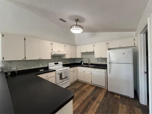a kitchen with a refrigerator a sink and cabinets