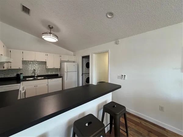 a kitchen with stainless steel appliances granite countertop a refrigerator a stove and a sink