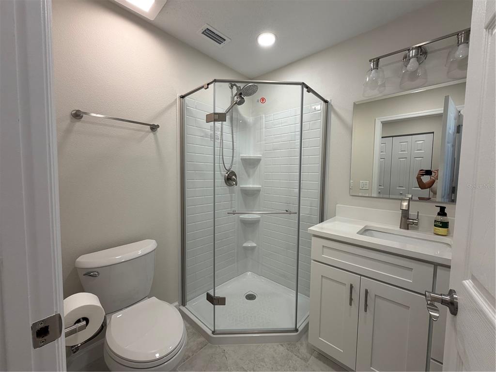 2723 West Arch Street Tampa, FL 33607 - Photo 8 of 14 a bathroom with a shower sink vanity mirror and toilet