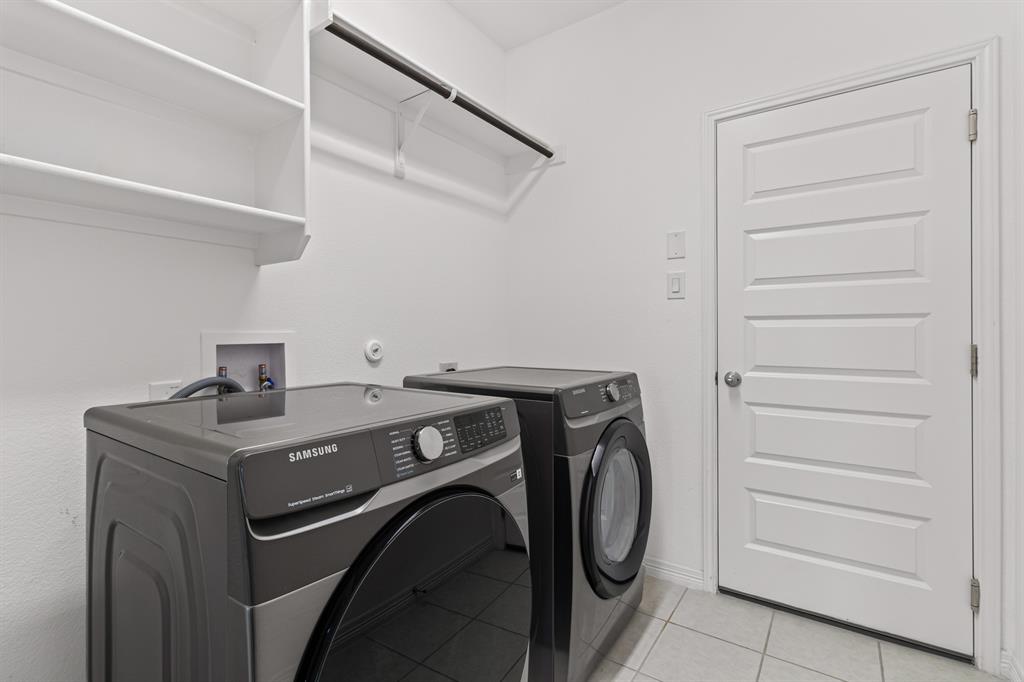 20520 Carries Ranch Road Pflugerville, TX 78660 - Photo 24 of 26 Laundry area with light tile patterned flooring and washer and clothes dryer
