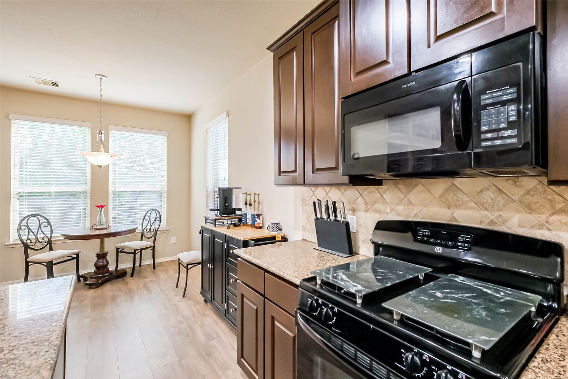4718 Sedgewood Drive Rosenberg, TX 77471 - Photo 11 of 23 a kitchen with a stove a sink and a microwave