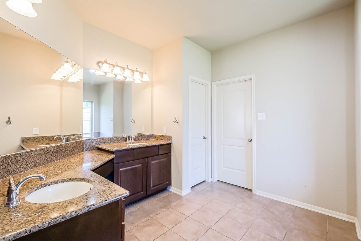 4718 Sedgewood Drive Rosenberg, TX 77471 - Photo 13 of 23 a spacious bathroom with a granite countertop double vanity sink and a mirror
