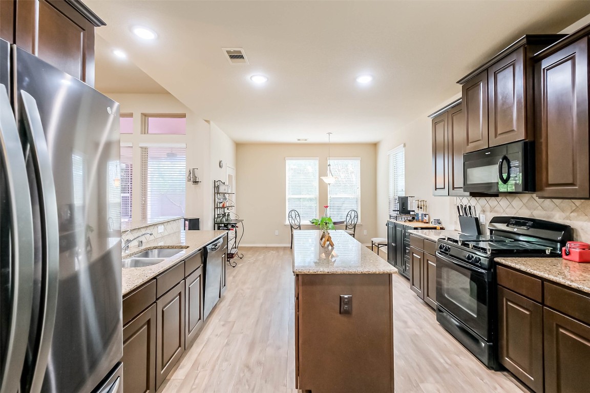 4718 Sedgewood Drive Rosenberg, TX 77471 - Photo 6 of 23 a kitchen with stainless steel appliances granite countertop a refrigerator stove microwave and sink