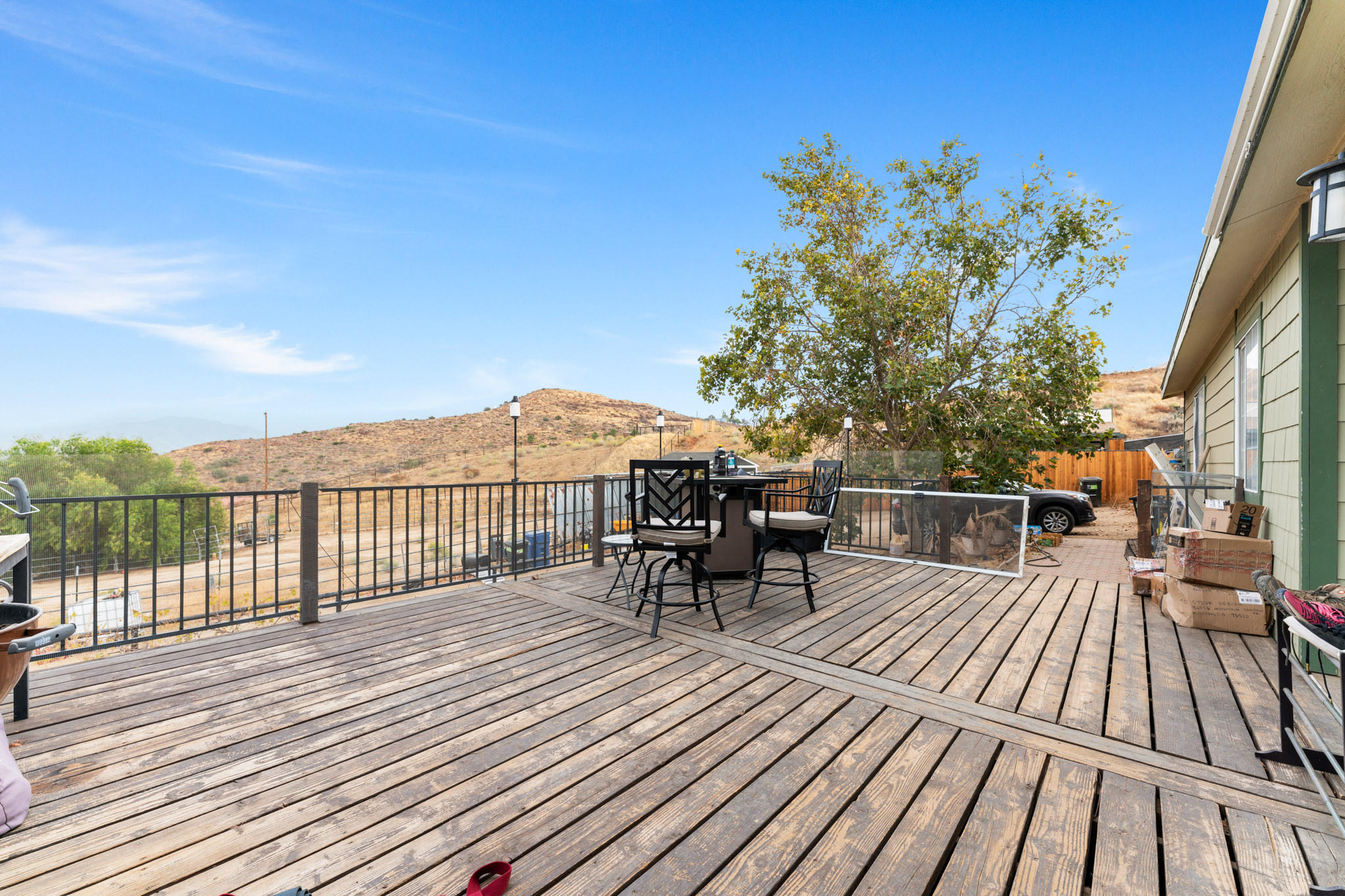 32035 Mountain Shadow Road Acton, CA 93510 - Photo 12 of 34 a view of a roof deck with table and chairs a barbeque with wooden floor and fence