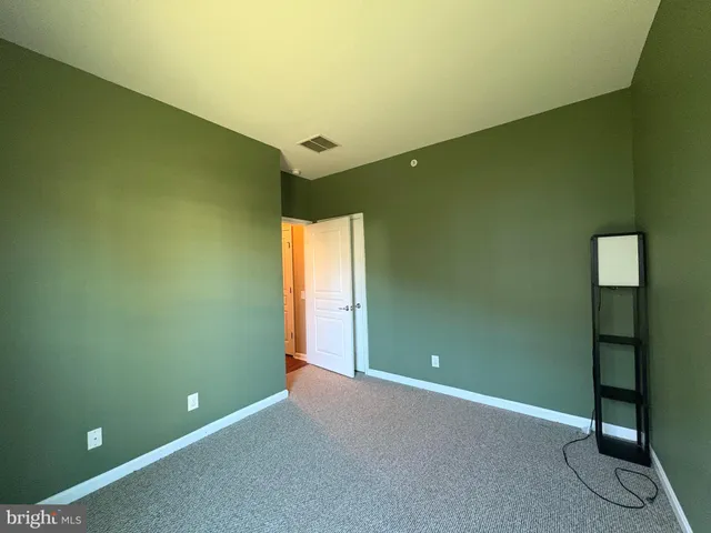 a view of an empty room with window and stairs