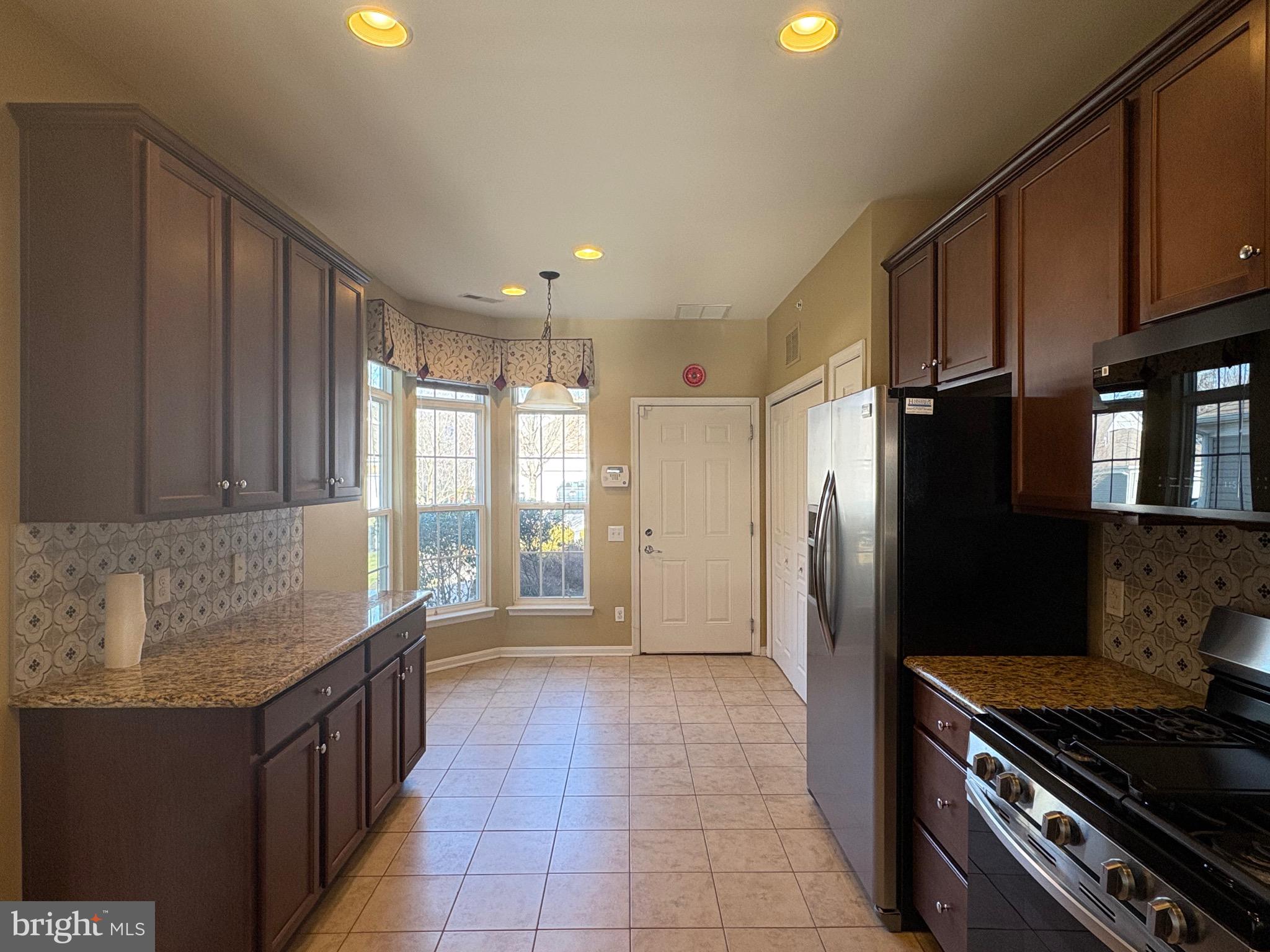 580 Prizer Court Downingtown, PA 19335 - Photo 2 of 28 a kitchen with granite countertop a refrigerator stove and cabinets