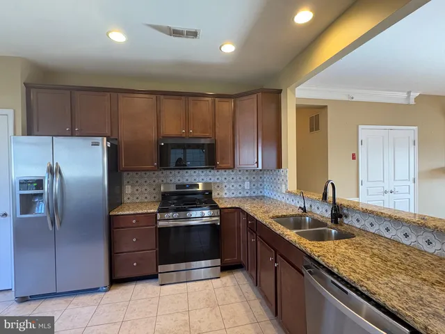 a kitchen with stainless steel appliances granite countertop a sink counter space cabinets and stainless steel appliances