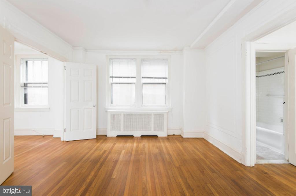 2100-2 Walnut Street, Unit 12K Philadelphia, PA 19103 - Photo 22 of 34 an empty room with wooden floor and windows