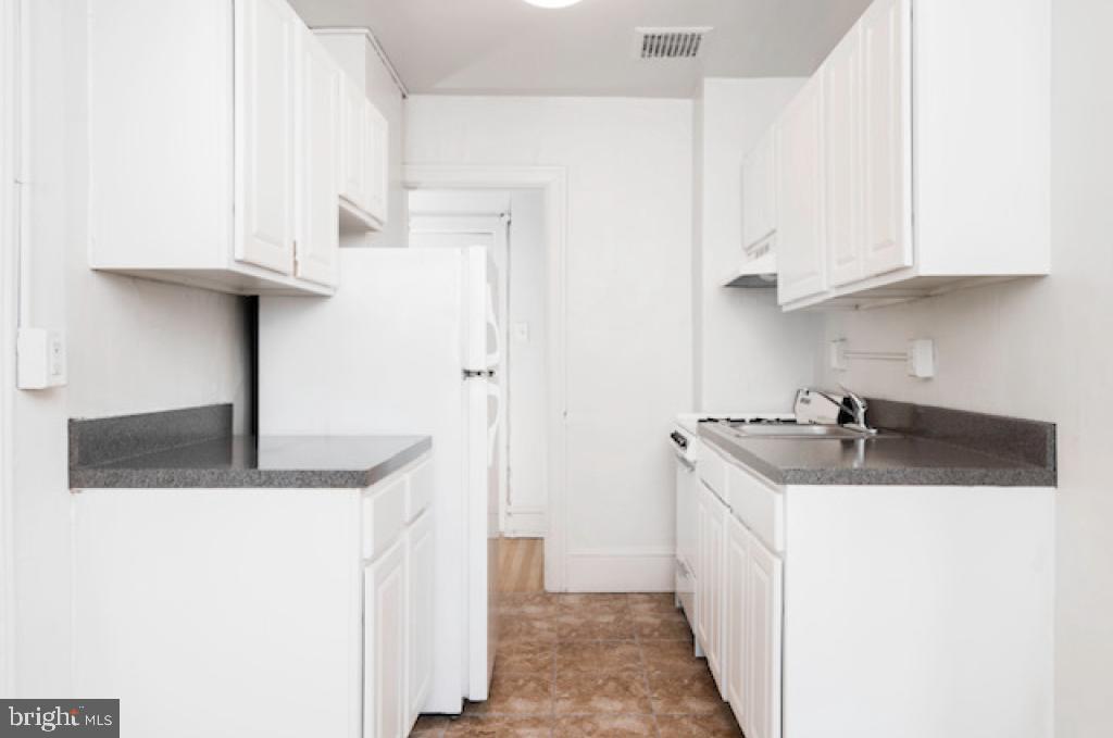 2100-2 Walnut Street, Unit 12K Philadelphia, PA 19103 - Photo 29 of 34 a kitchen with stainless steel appliances granite countertop a sink a stove and a refrigerator