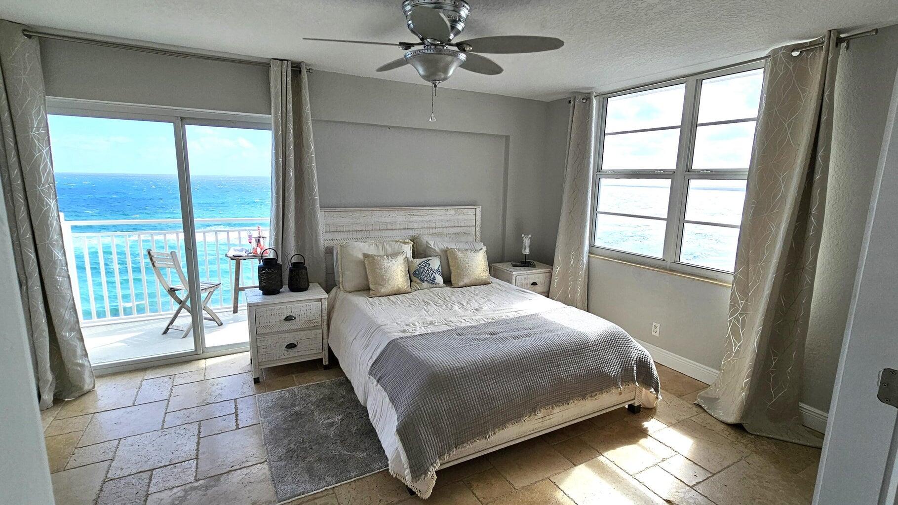 4511 South Ocean Boulevard, Unit 807 Highland Beach, FL 33487 - Photo 11 of 21 a bedroom with a bed and large windows