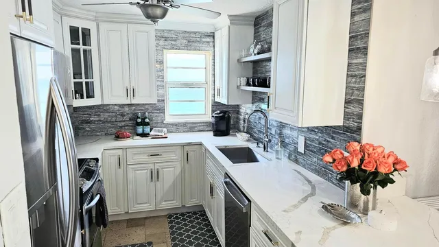 a kitchen with stainless steel appliances a sink a stove a refrigerator and cabinets