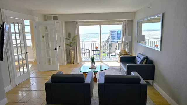 a living room with furniture and a floor to ceiling window
