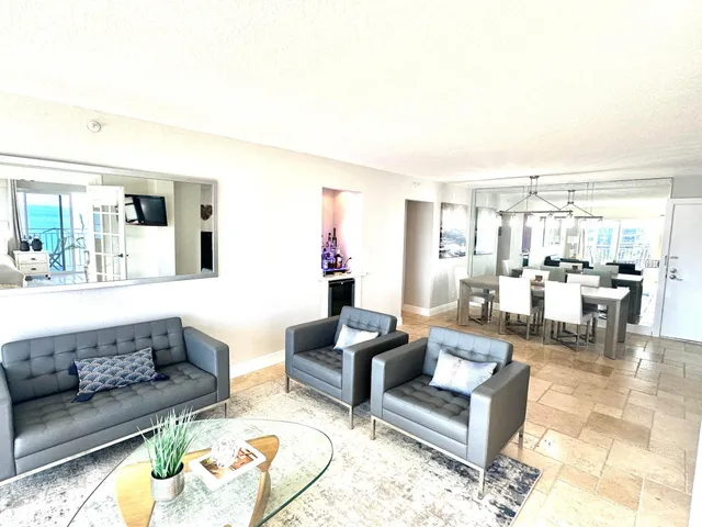 a living room with furniture and view of kitchen