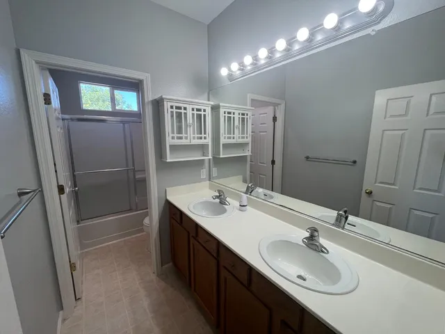 a bathroom with double vanity sink and a mirror