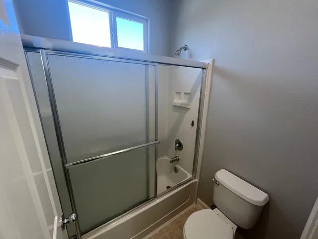 a bathroom with a toilet and a shower