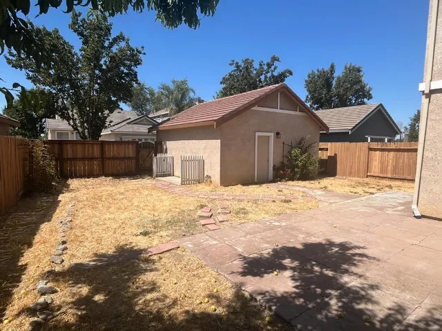 a large house with a outdoor space covered with snow in the background