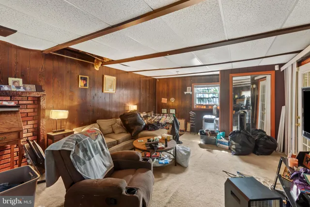 a living room with furniture ceiling fan and a large window