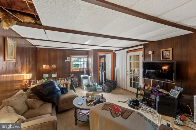 a living room with furniture a flat screen tv and a window