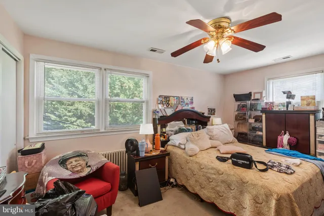 a bedroom with furniture a flat screen tv and a window