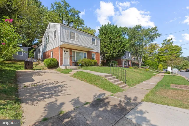 a front view of a house with a yard and trees