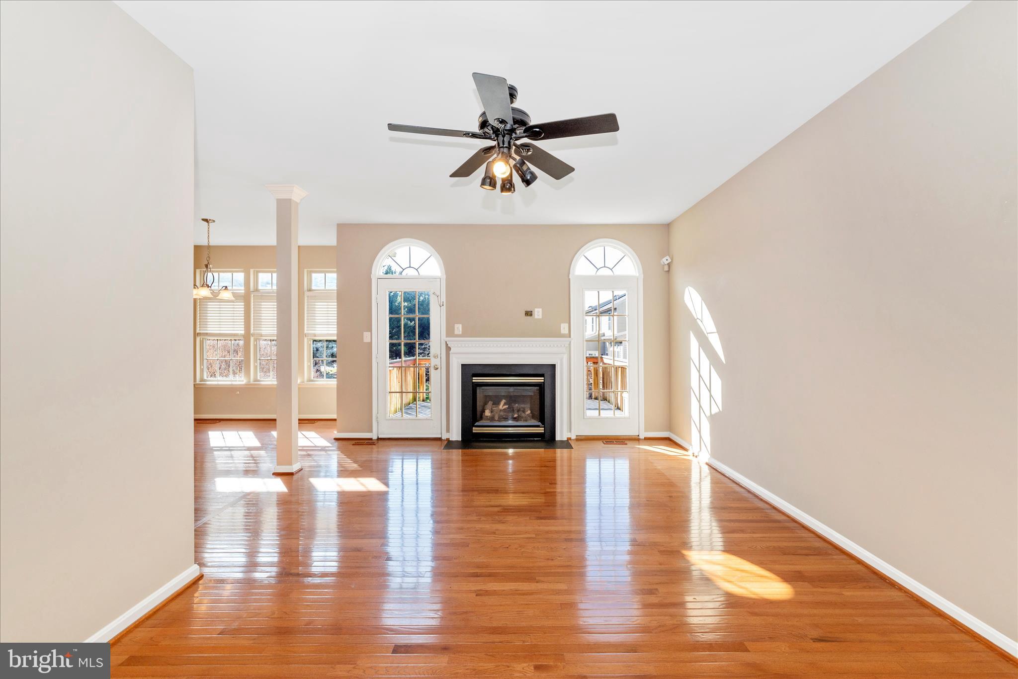2409 Rippling Brook Road Frederick, MD 21701 - Photo 20 of 69 a view of a livingroom with a fireplace a ceiling fan and windows