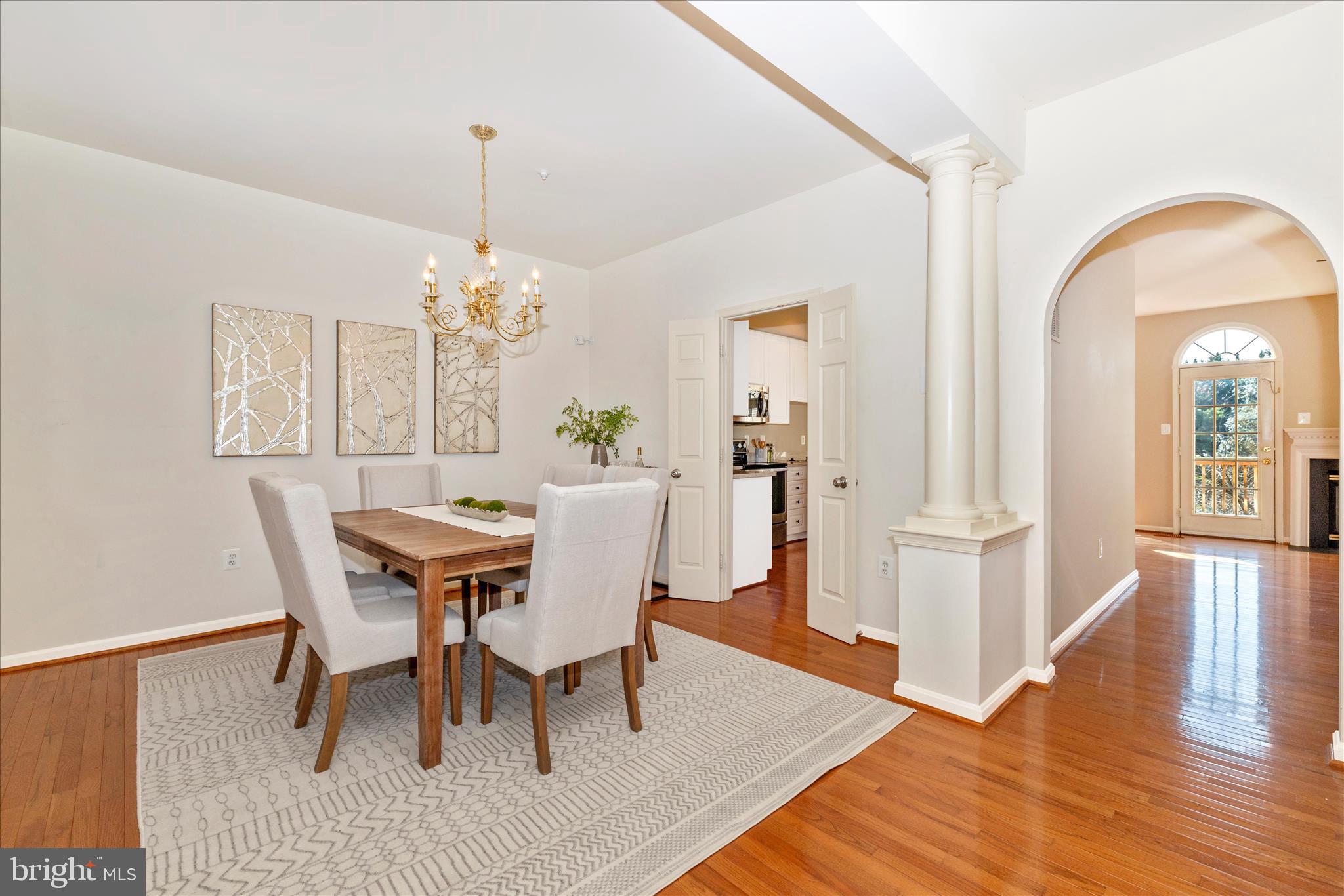 2409 Rippling Brook Road Frederick, MD 21701 - Photo 10 of 69 a dining room with wooden floor a chandelier a wooden table and chairs
