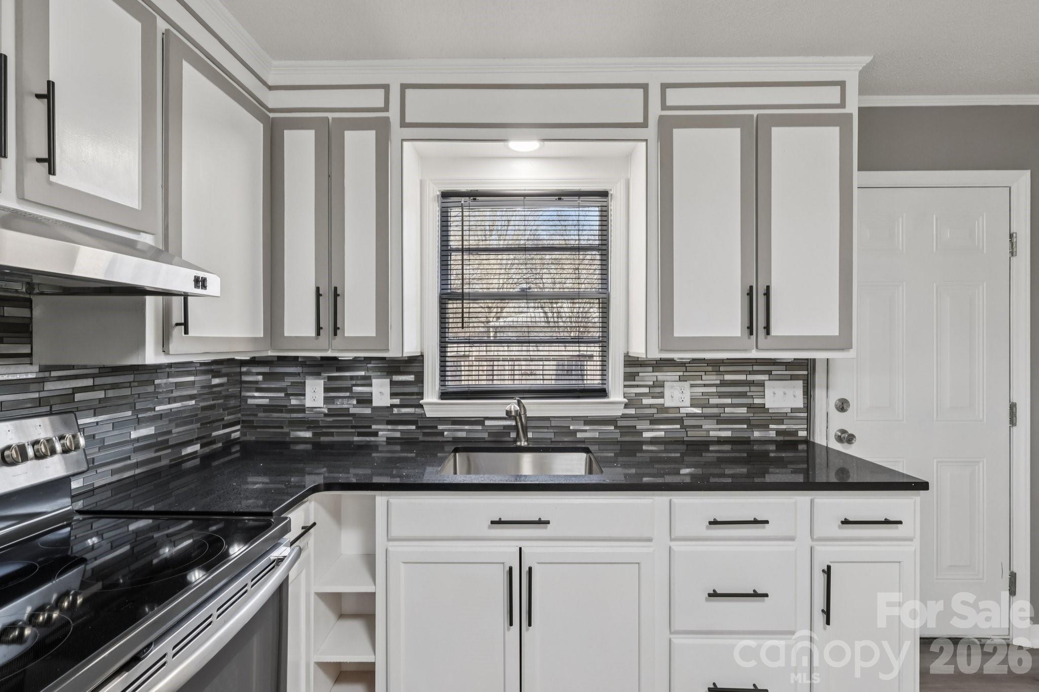 3207 Valley Dale Road Monroe, NC 28110 - Photo 11 of 30 a kitchen with granite countertop a sink stove and cabinets