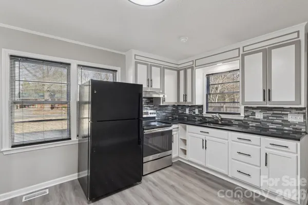 a kitchen with granite countertop stainless steel appliances a refrigerator sink and cabinets