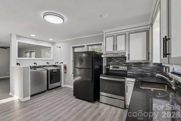 a kitchen with a refrigerator and a stove top oven