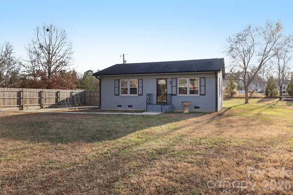 a view of a house with backyard and trees