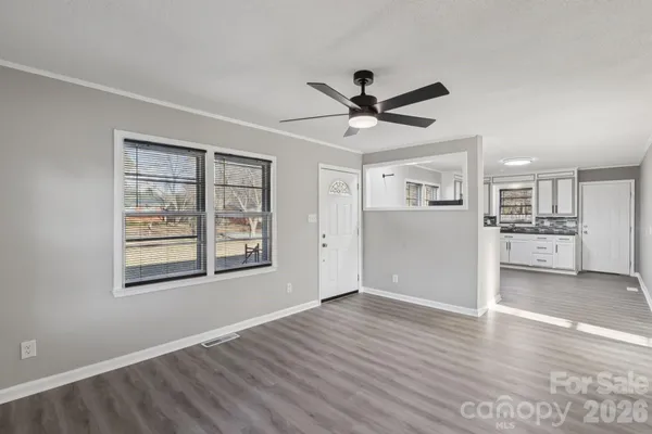 a view of a big room with wooden floor and windows