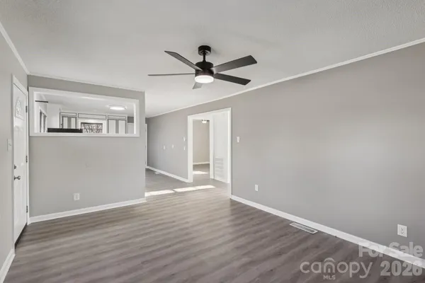a view of an empty room with wooden floor
