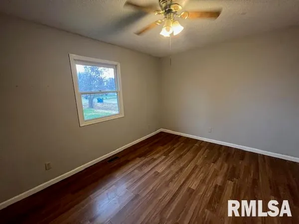 a view of a room with wooden floor and a window