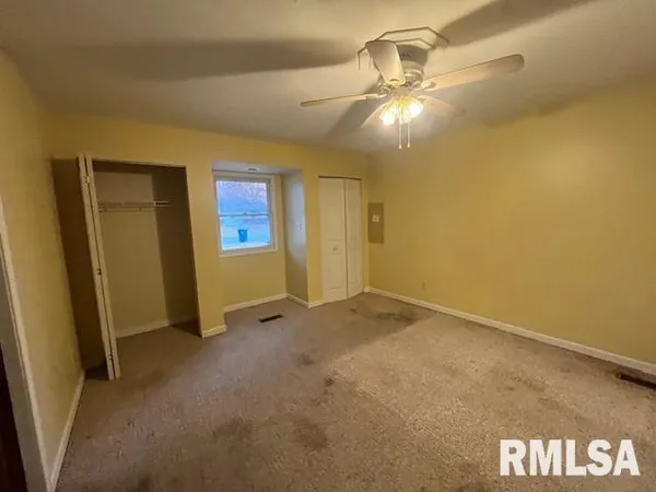a view of empty room with wooden floor and ceiling fan