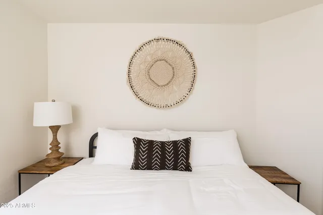 a bedroom with a bed and a painting on the wall