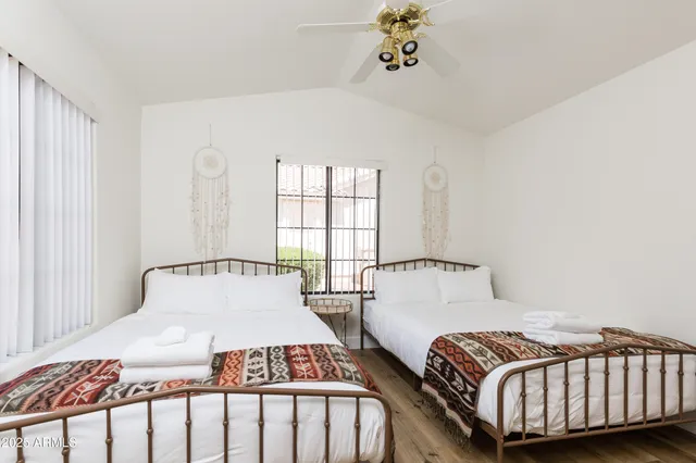 a bedroom with two beds and a window