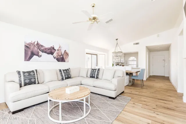 a living room with furniture a chandelier and a rug