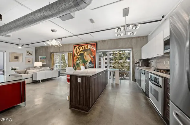 a large kitchen with kitchen island a large counter space a sink stainless steel appliances and cabinets