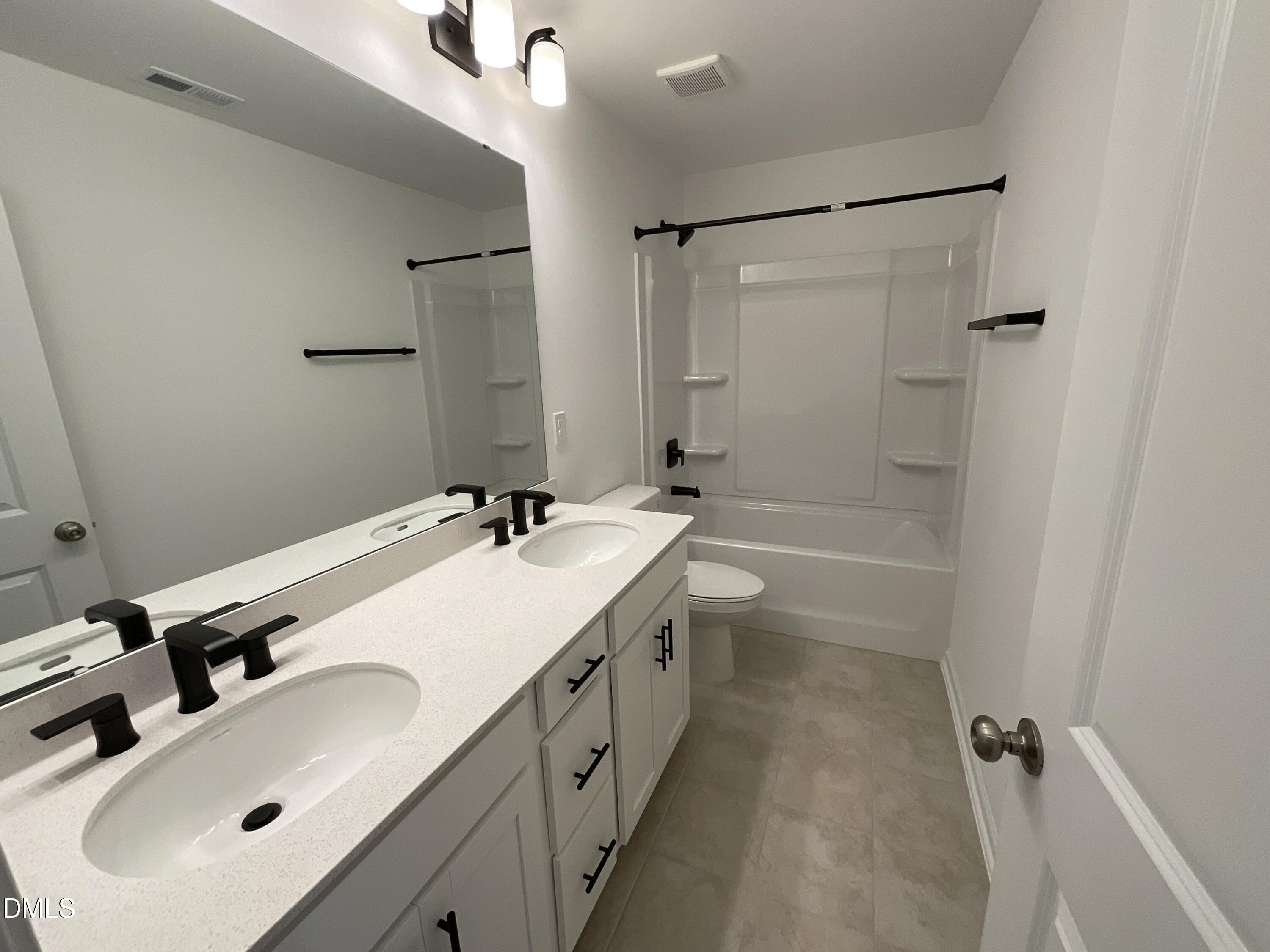 8712 Wardle Court Wake Forest, NC 27587 - Photo 12 of 33 a bathroom with a sink double vanity and a tub