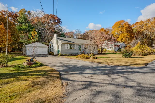 a view of a house with a big yard and large trees