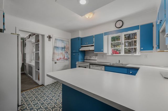 a kitchen with stainless steel appliances a refrigerator and a stove top oven