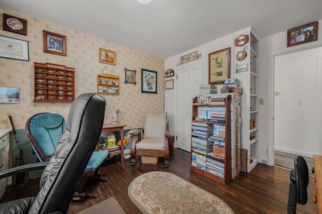 a view of a workspace with furniture and wooden floor
