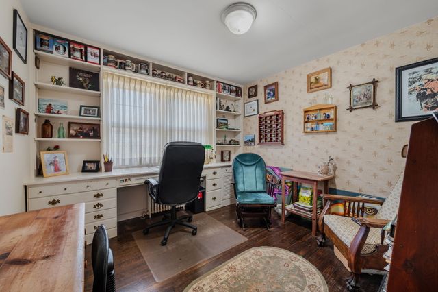 a view of a workspace with furniture and a window