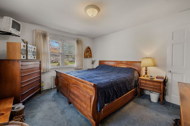 a spacious bedroom with a bed and a refrigerator