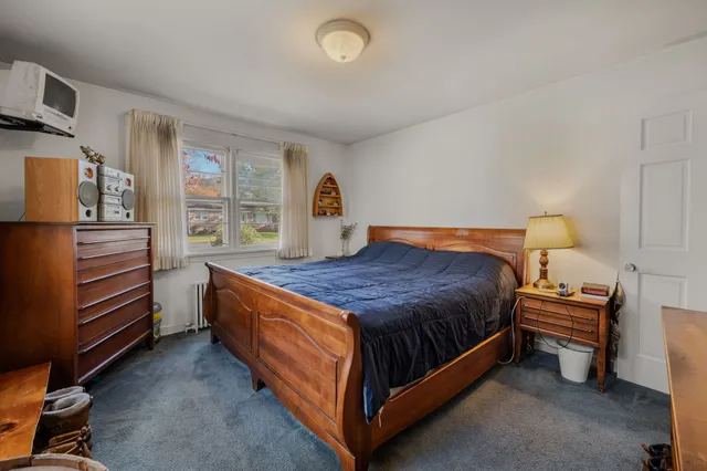 a spacious bedroom with a bed and a refrigerator