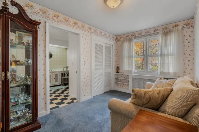 a living room with furniture a large window and a glass door