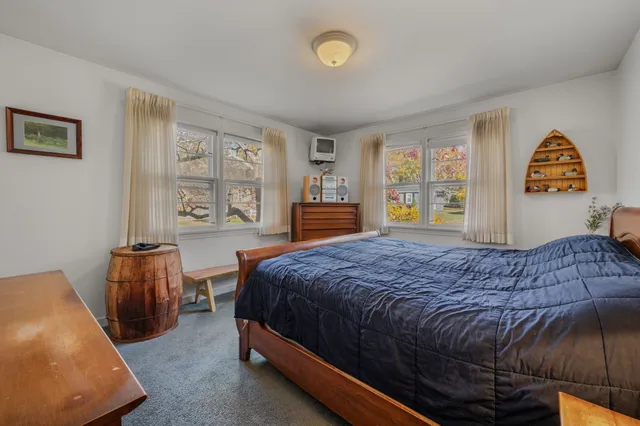a bedroom with a bed and a dresser next to a window
