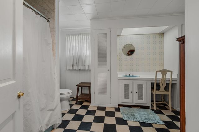 a bathroom with a sink a toilet a mirror and shower