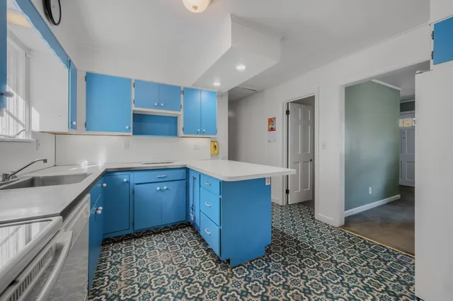 a kitchen with a sink a stove cabinets and wooden floor